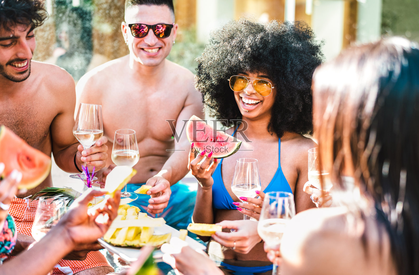 快乐的朋友群喝白葡萄酒香槟在泳池边的派对-生活风格的度假概念与年轻的男孩和女孩一起享受夏日在豪华的位置照片摄影图片
