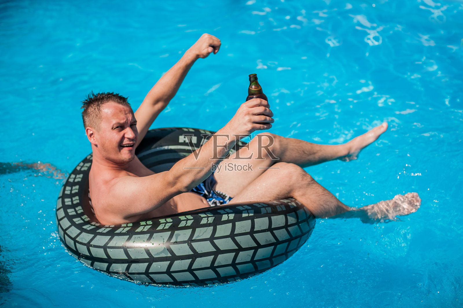 快乐的年轻人放松和喝啤酒在游泳池照片摄影图片