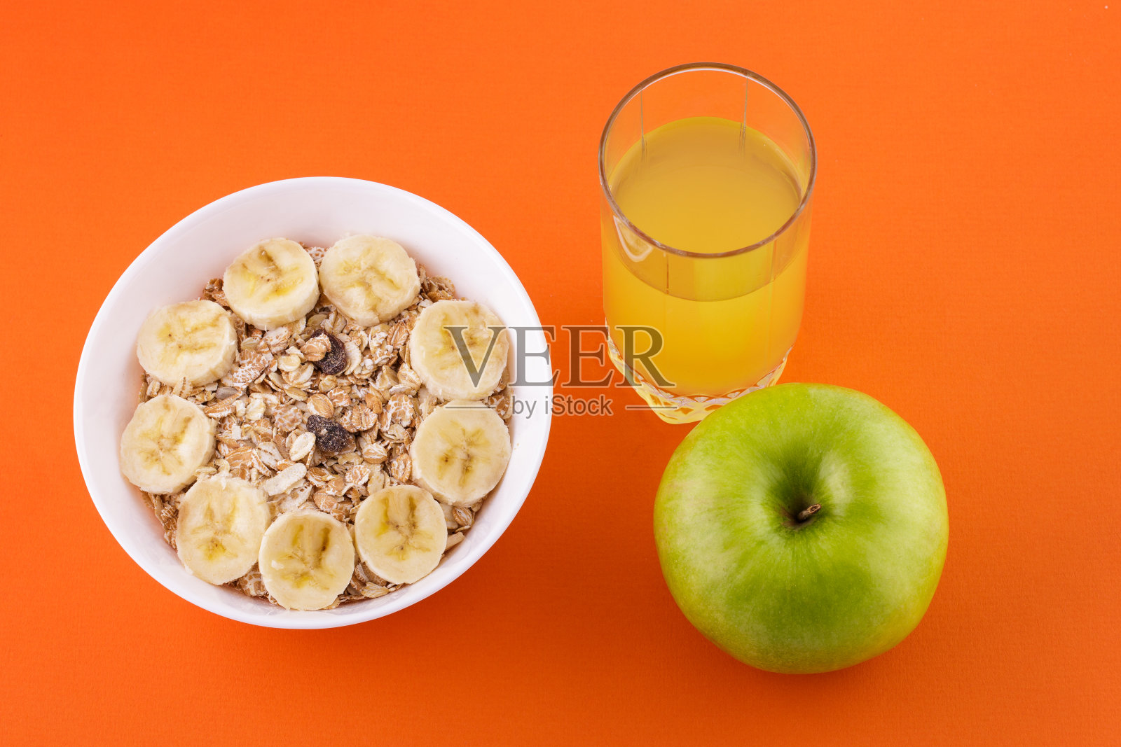 香蕉和鲜果汁燕麦片，橙底青苹果，饮食和健康食品理念照片摄影图片