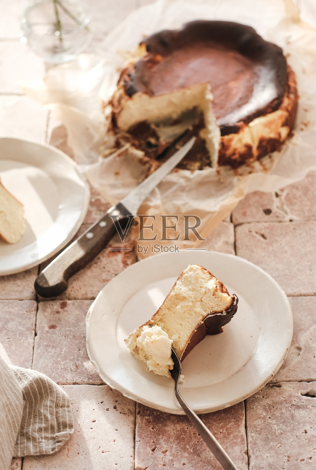 白色盘子上的自制圣塞巴斯蒂安烤奶酪蛋糕照片摄影图片
