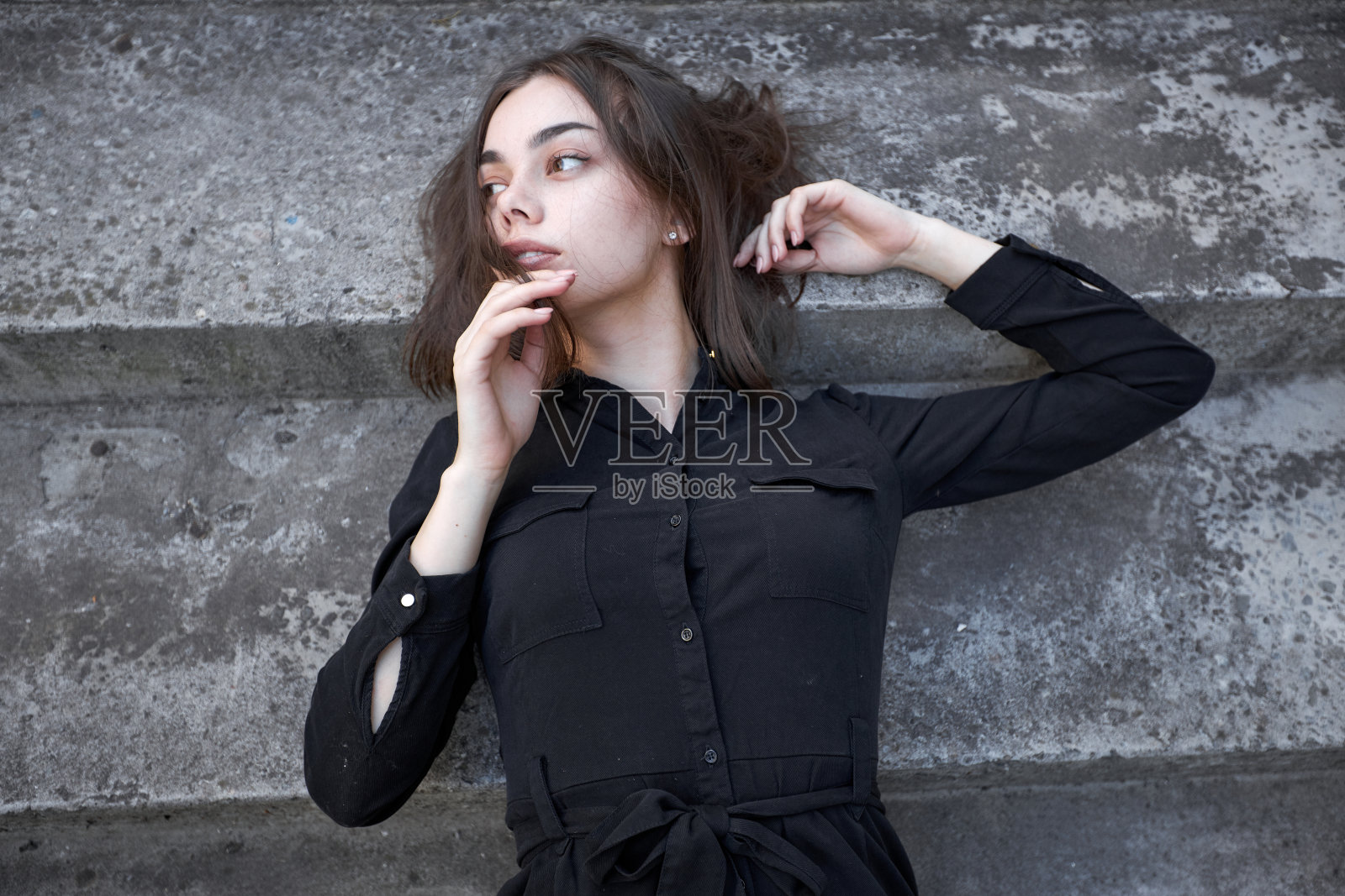 一个性感的黑发女人的时尚大头照，化妆穿着黑色的裙子在市区照片摄影图片