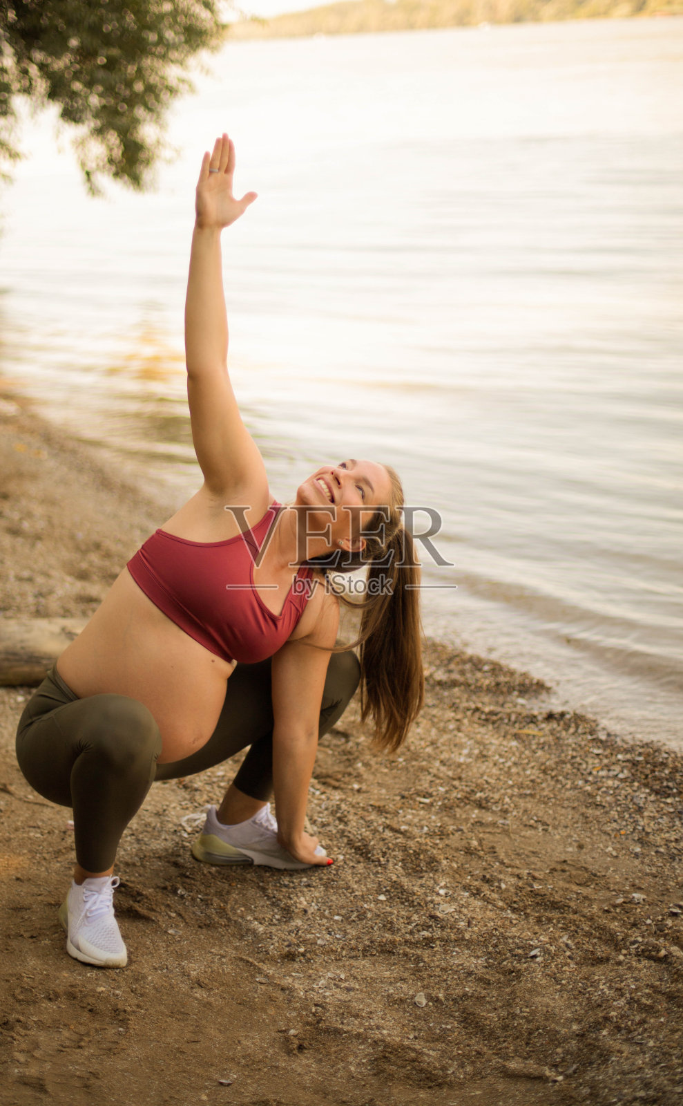 一个女人在湖上做瑜伽。照片摄影图片