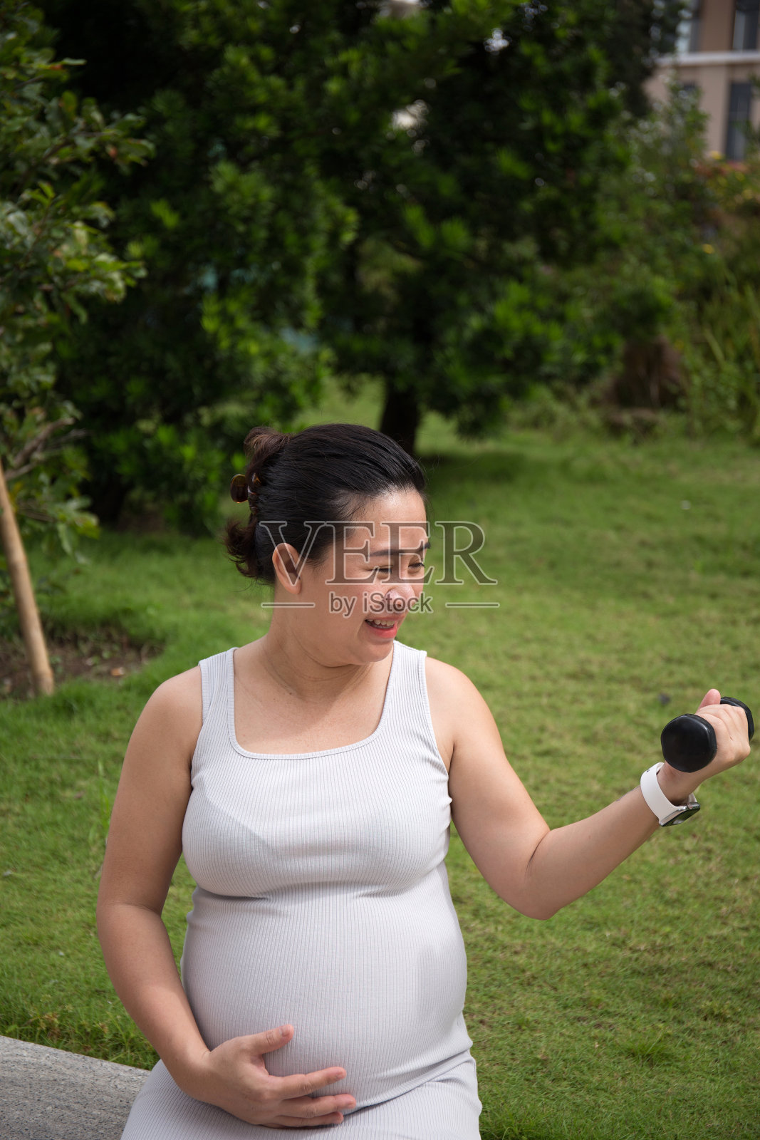 亚洲孕妇在公园里用哑铃做运动照片摄影图片