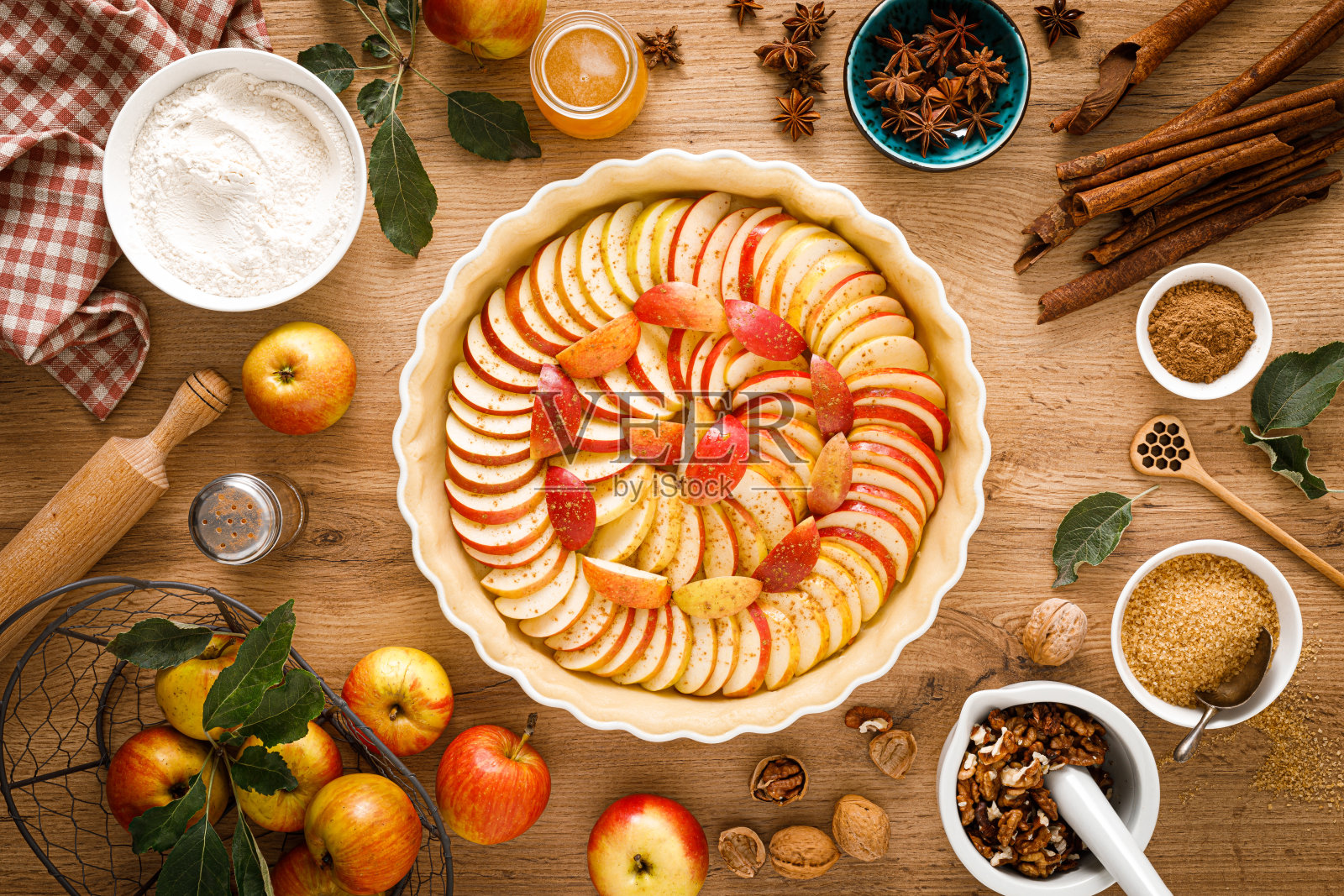 在木桌上用新鲜水果和核桃烹饪感恩节秋天的苹果派，俯视图照片摄影图片