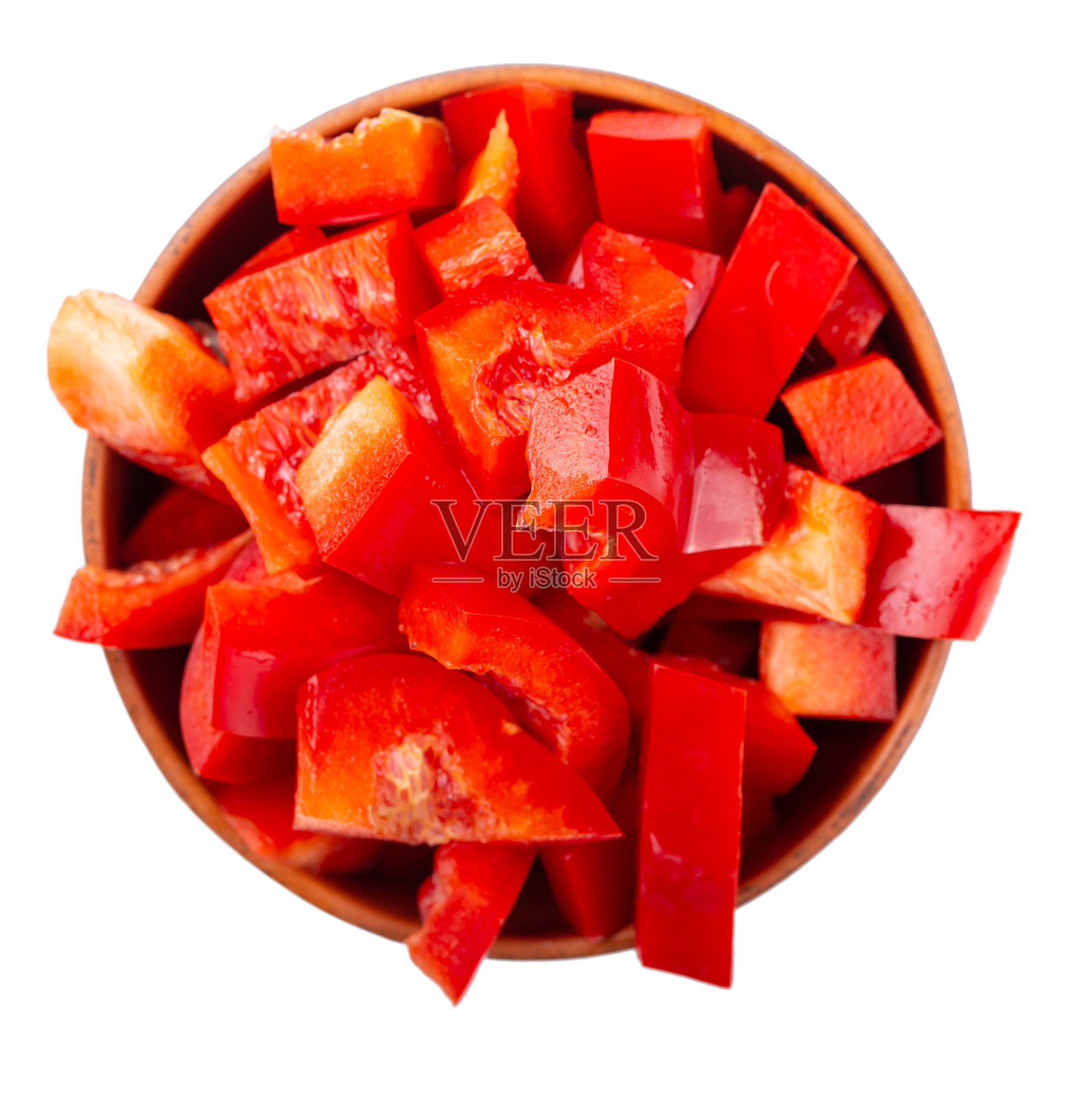 切成薄片的红甜椒在一个粘土碗孤立在白色的背景。新鲜健康的蔬菜。前视图。照片摄影图片