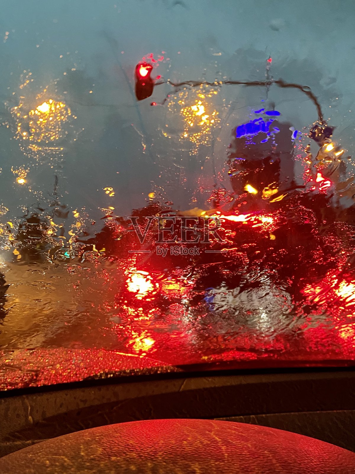 透过被雨弄脏的车窗可以看到城市的交通灯照片摄影图片