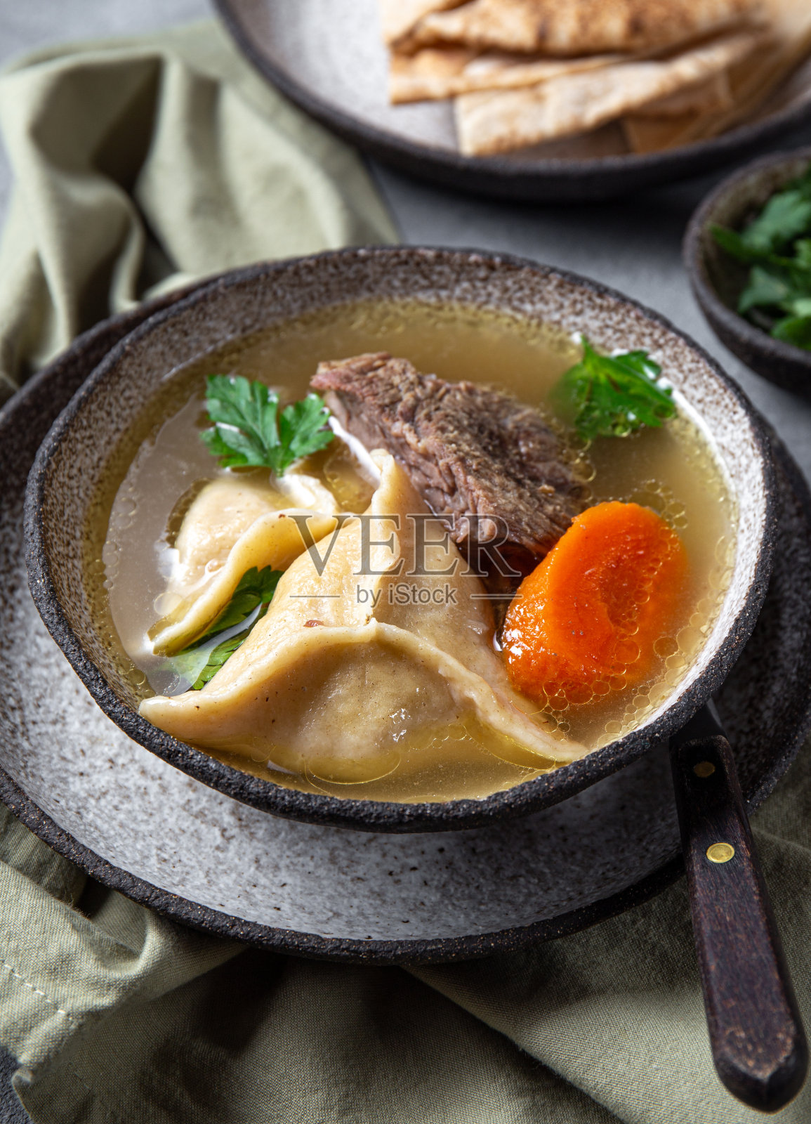 传统的犹太食物是用灰色的碗盛饺子汤。照片摄影图片