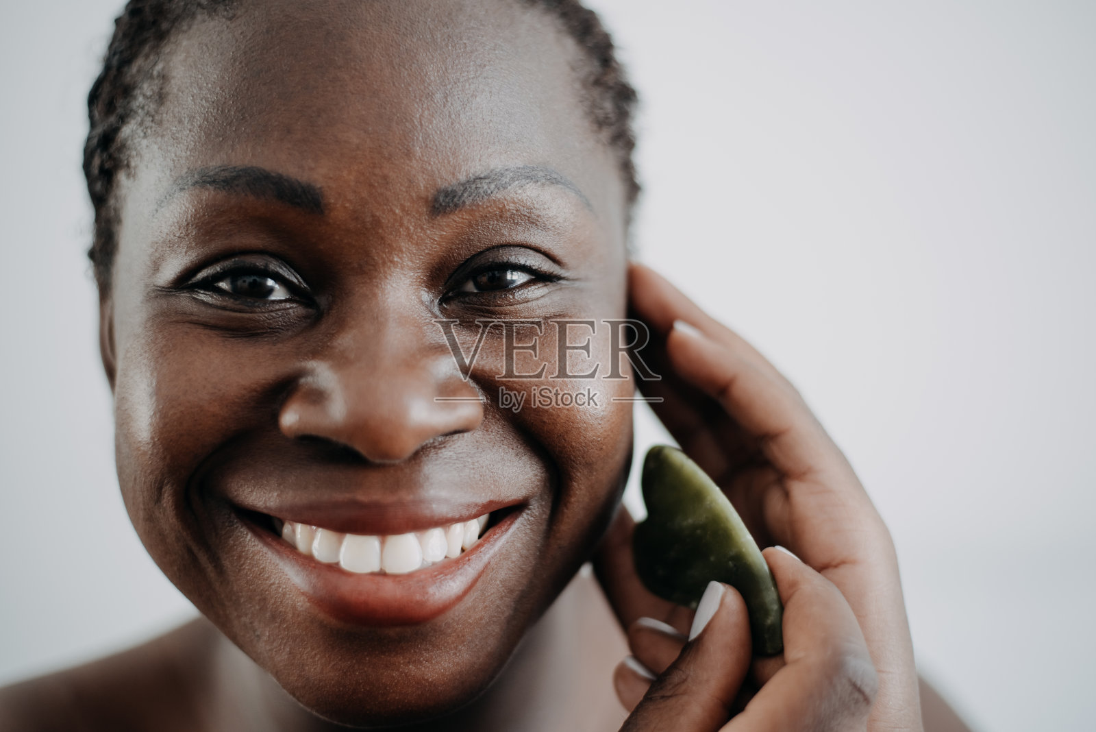 皮肤护理黑人女性皮肤护理使用刮痧石照片摄影图片