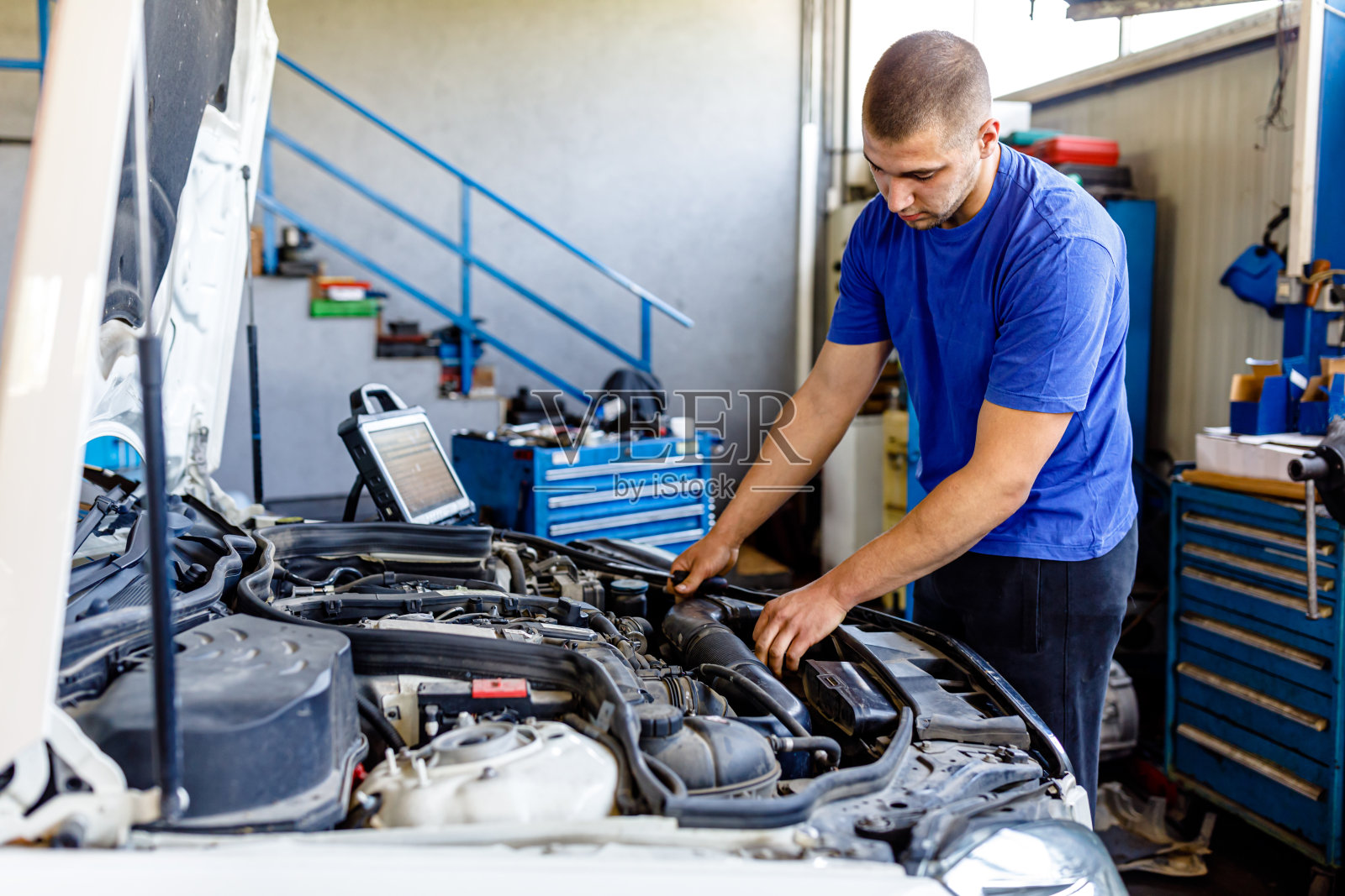 一位有经验的汽车修理工正在汽车服务公司检查汽车修理工。照片摄影图片
