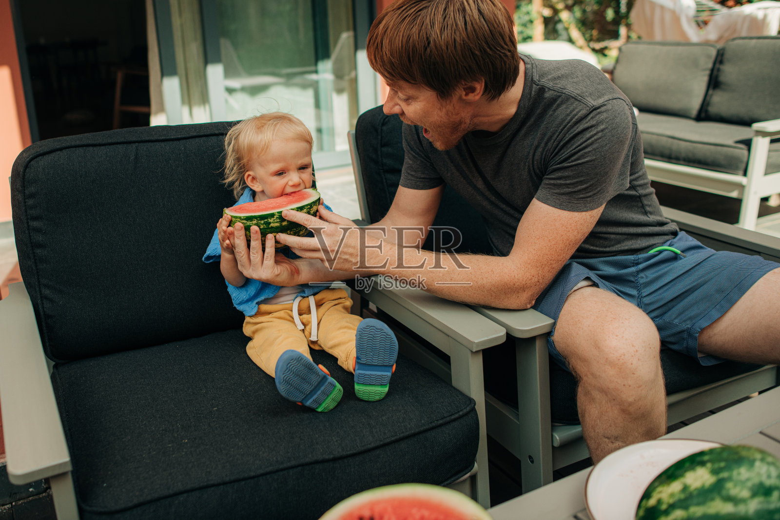 快乐的爸爸用西瓜喂小女孩照片摄影图片