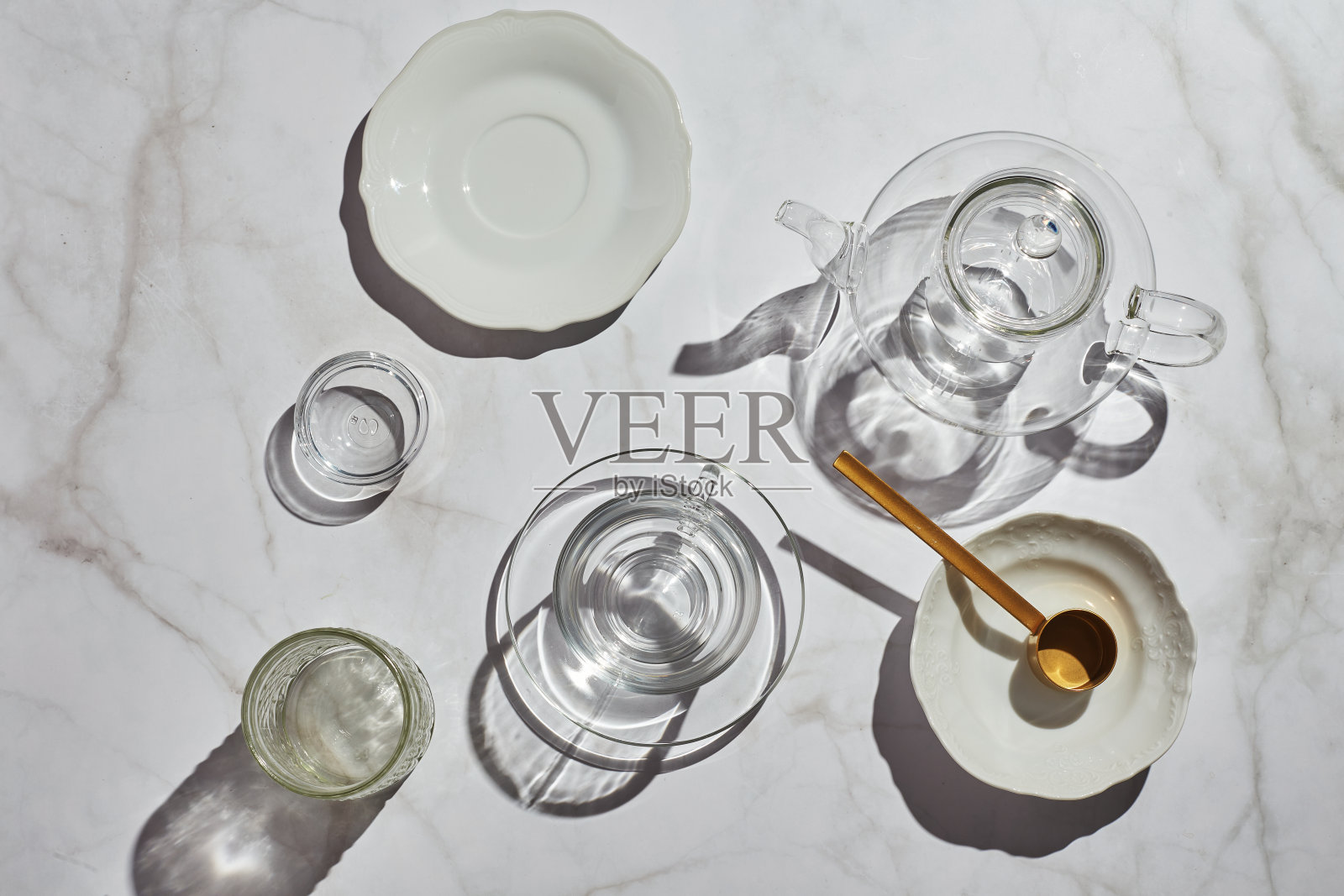 在阳光明媚的日子，白色桌子上的茶帘玻璃器皿的高角度视图照片摄影图片