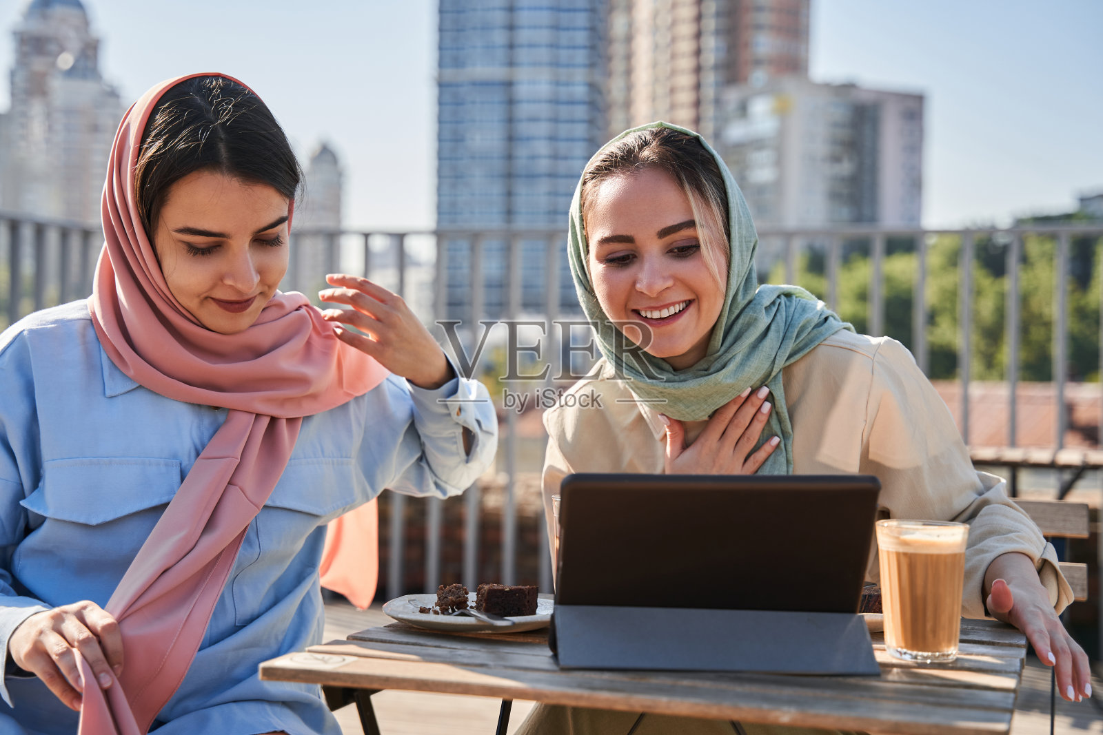 伊斯兰姐妹们在平板电脑前通过视频通话与亲戚们聊天照片摄影图片