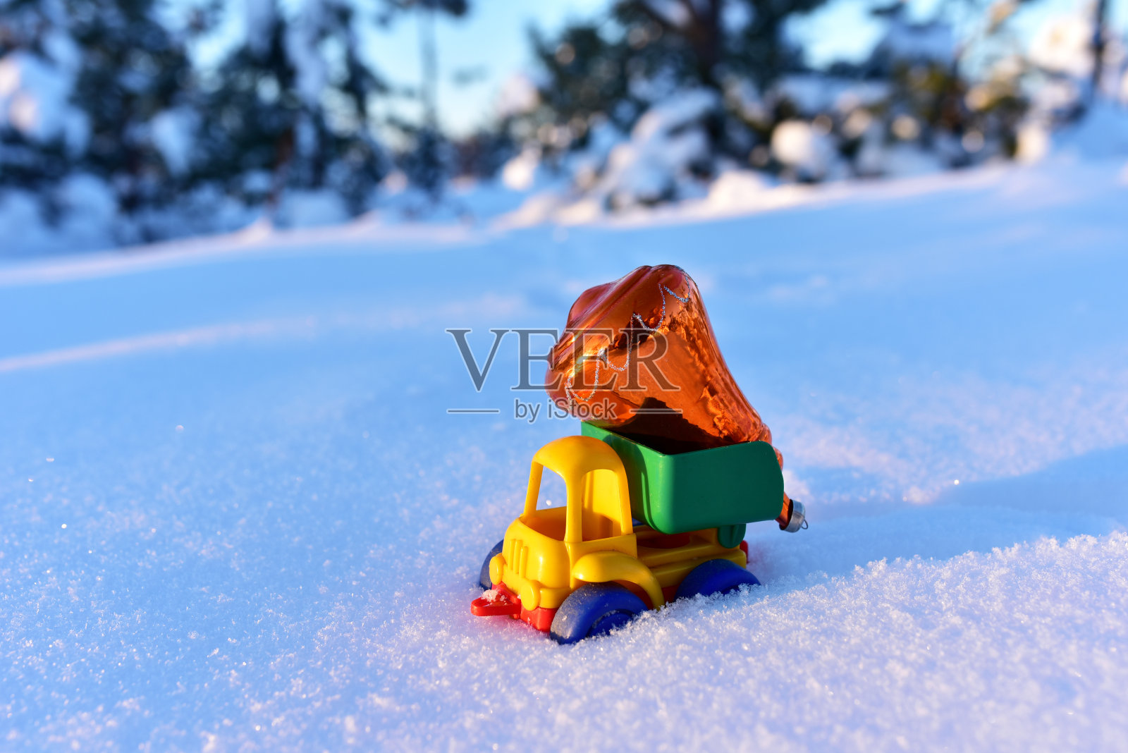 以森林里的白雪为背景的圣诞球玩具卡车。照片摄影图片