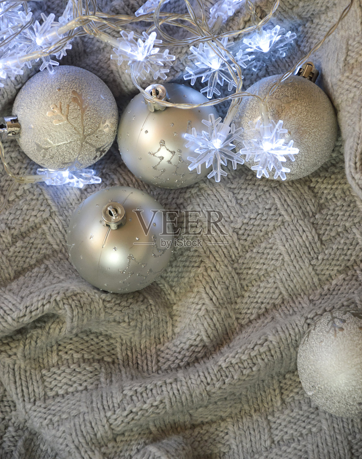 闪亮的灰色圣诞球和针织格子布上的蓝色花环。圣诞节和新年的背景。冬天的假期。照片摄影图片