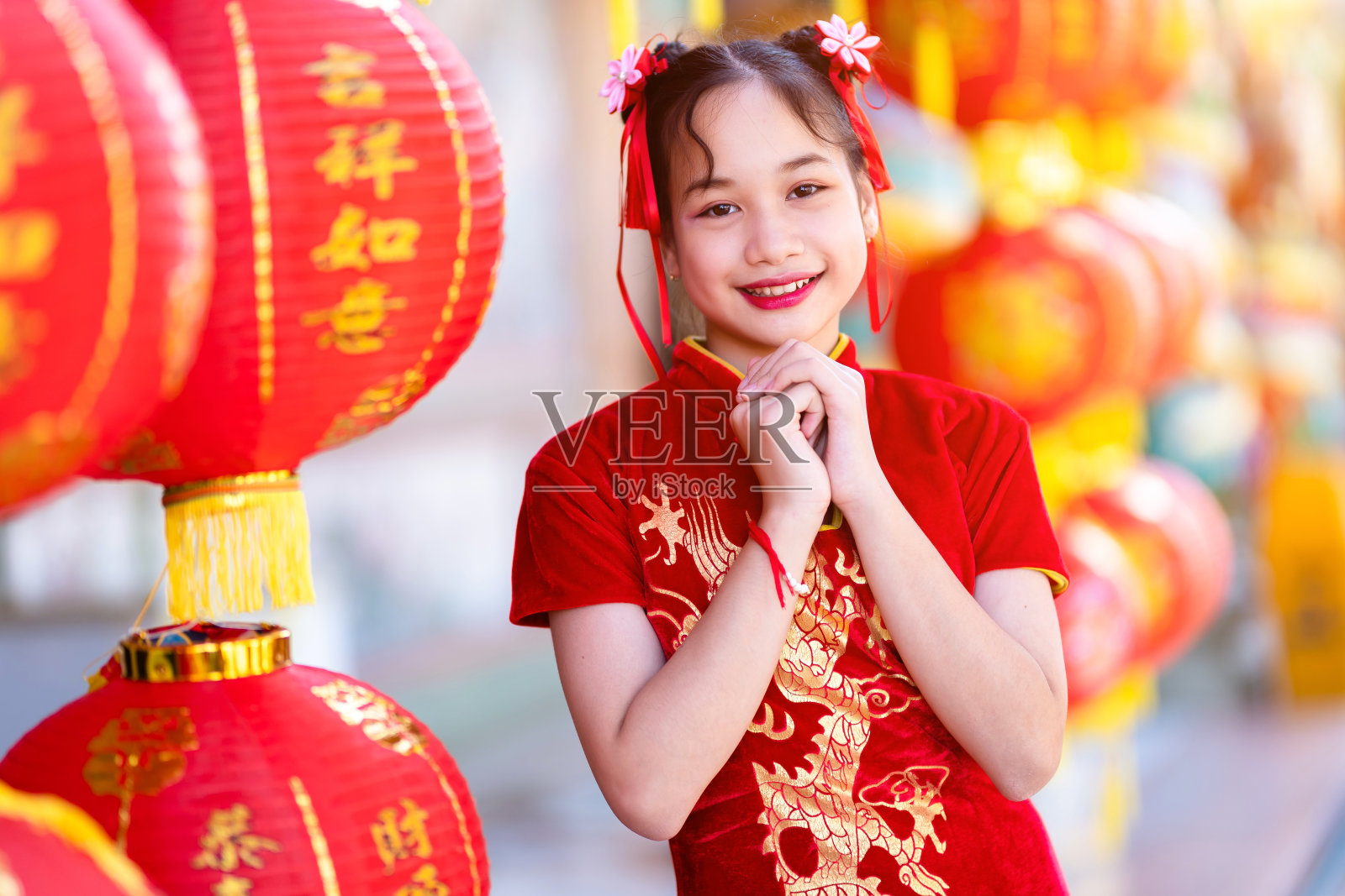 人像美丽的微笑，可爱的亚洲女孩穿着红色的传统中国旗袍，红色的纸灯笼装饰中国新年在中国神社照片摄影图片