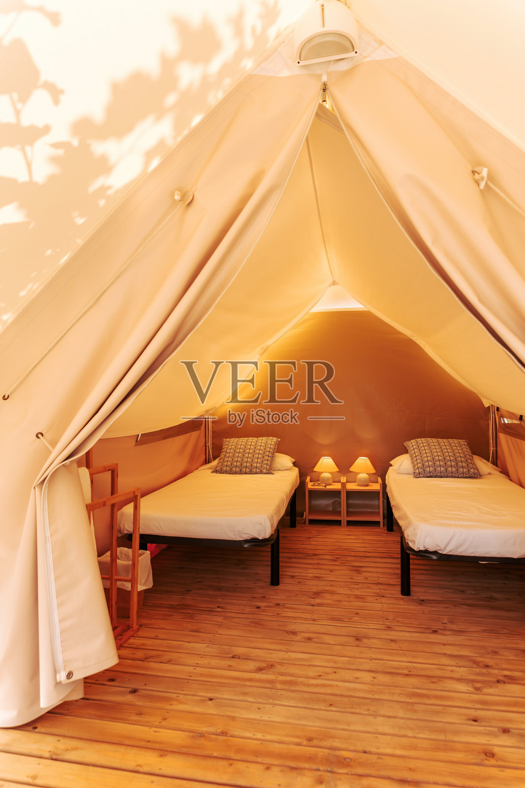 豪华帐篷，在阳光明媚的日子里，豪华而舒适的室内配有床。迷人的露营帐篷户外夏季假期和度假生活的概念照片摄影图片