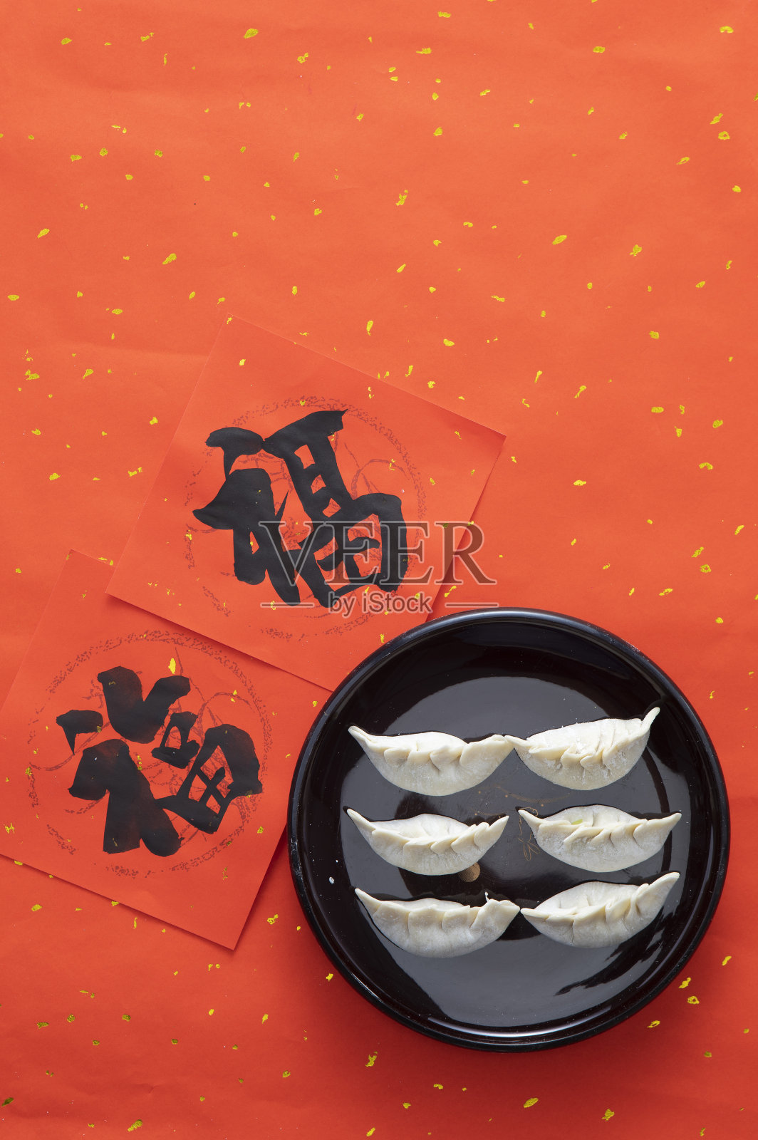 中国春节福字春联旁摆放着和圆圆满满的水饺元宝照片摄影图片