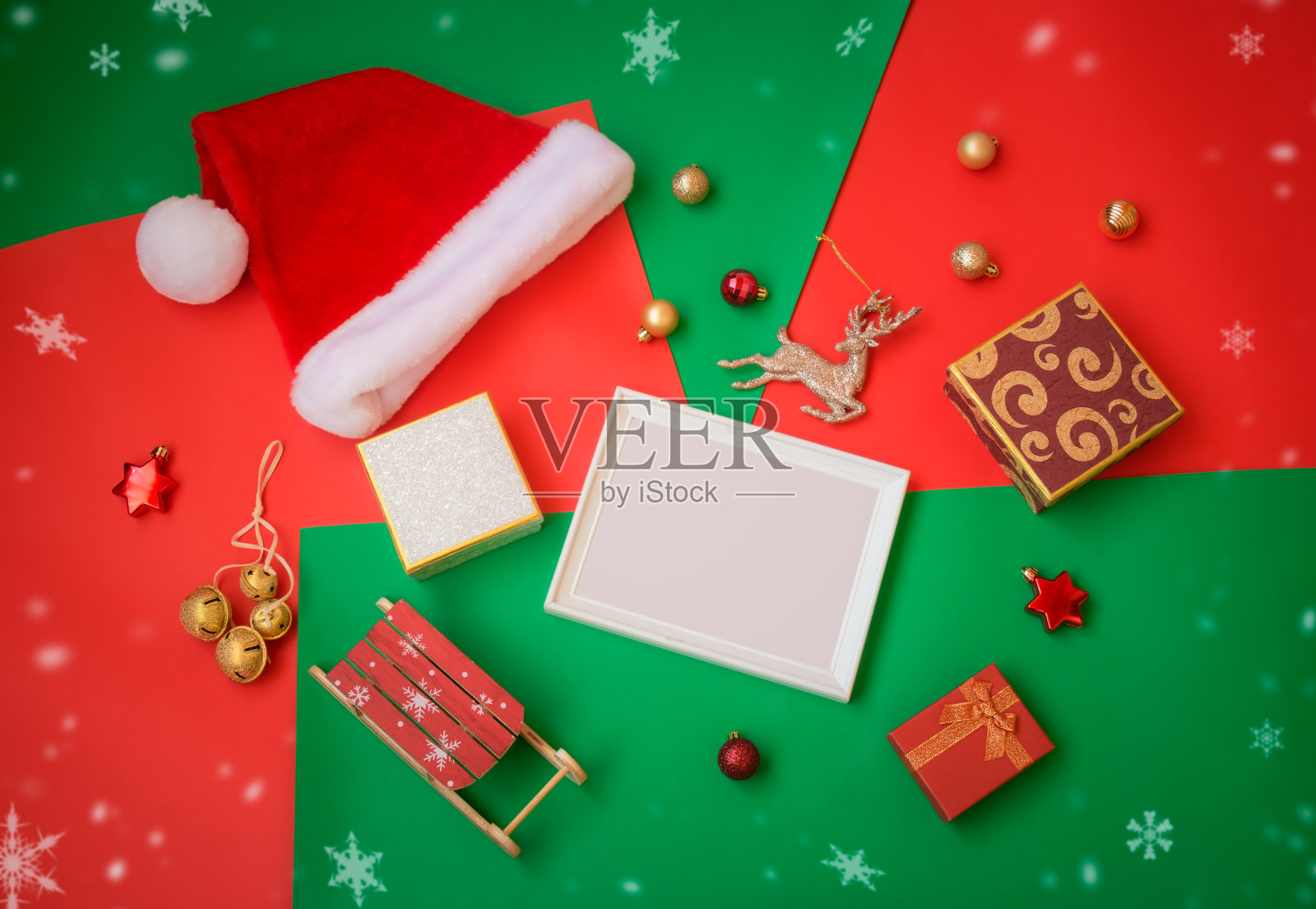 白色的框架，圣诞老人帽子，圣诞装饰品和彩色背景的礼物。照片摄影图片
