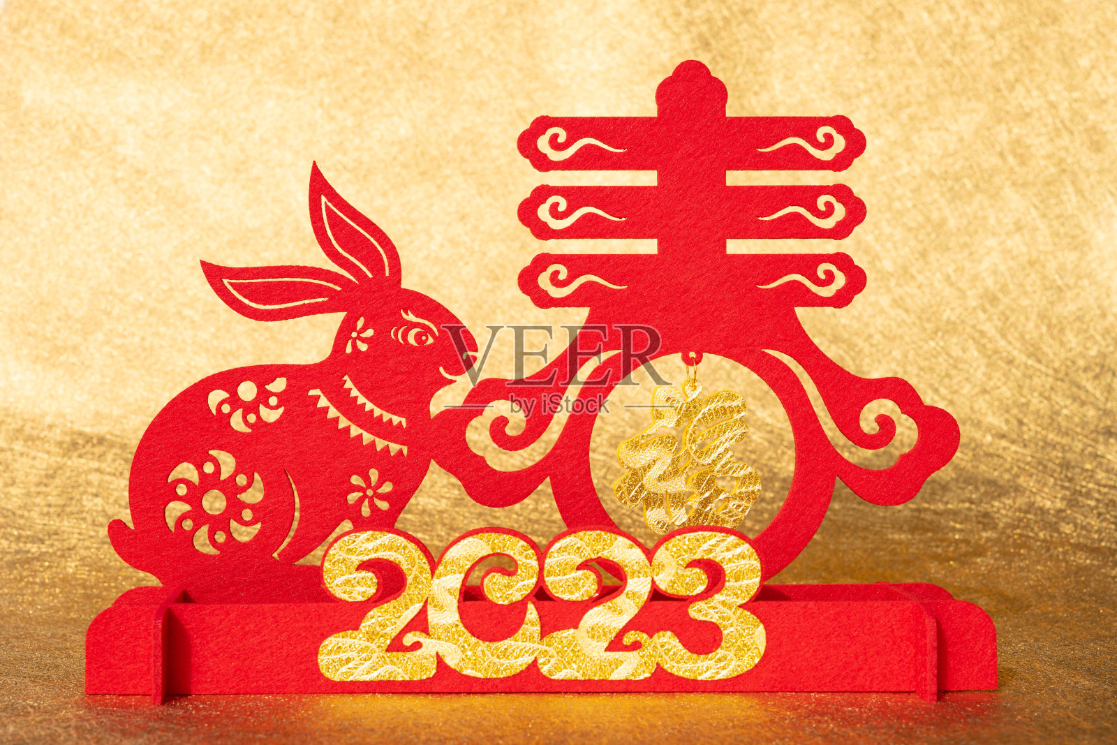 中国新年兔子吉祥物剪纸在金色背景上翻译的中文单词是幸运和春天没有标志没有商标照片摄影图片