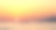 日落时，明亮的红橙黄天空和海面，以及休闲船只和山区海岸的剪影素材图片